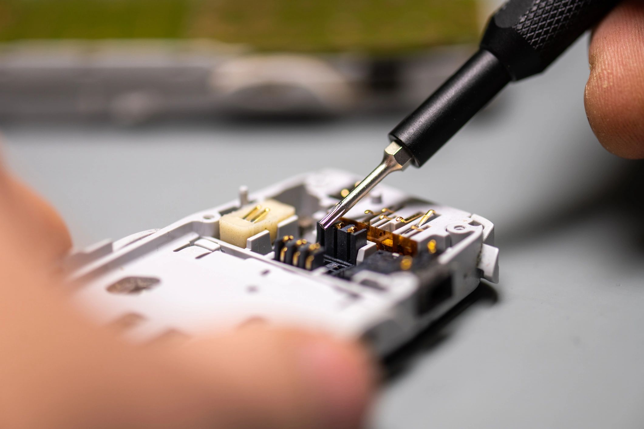 Technician disassembling a mobile phone for battery or internal repair