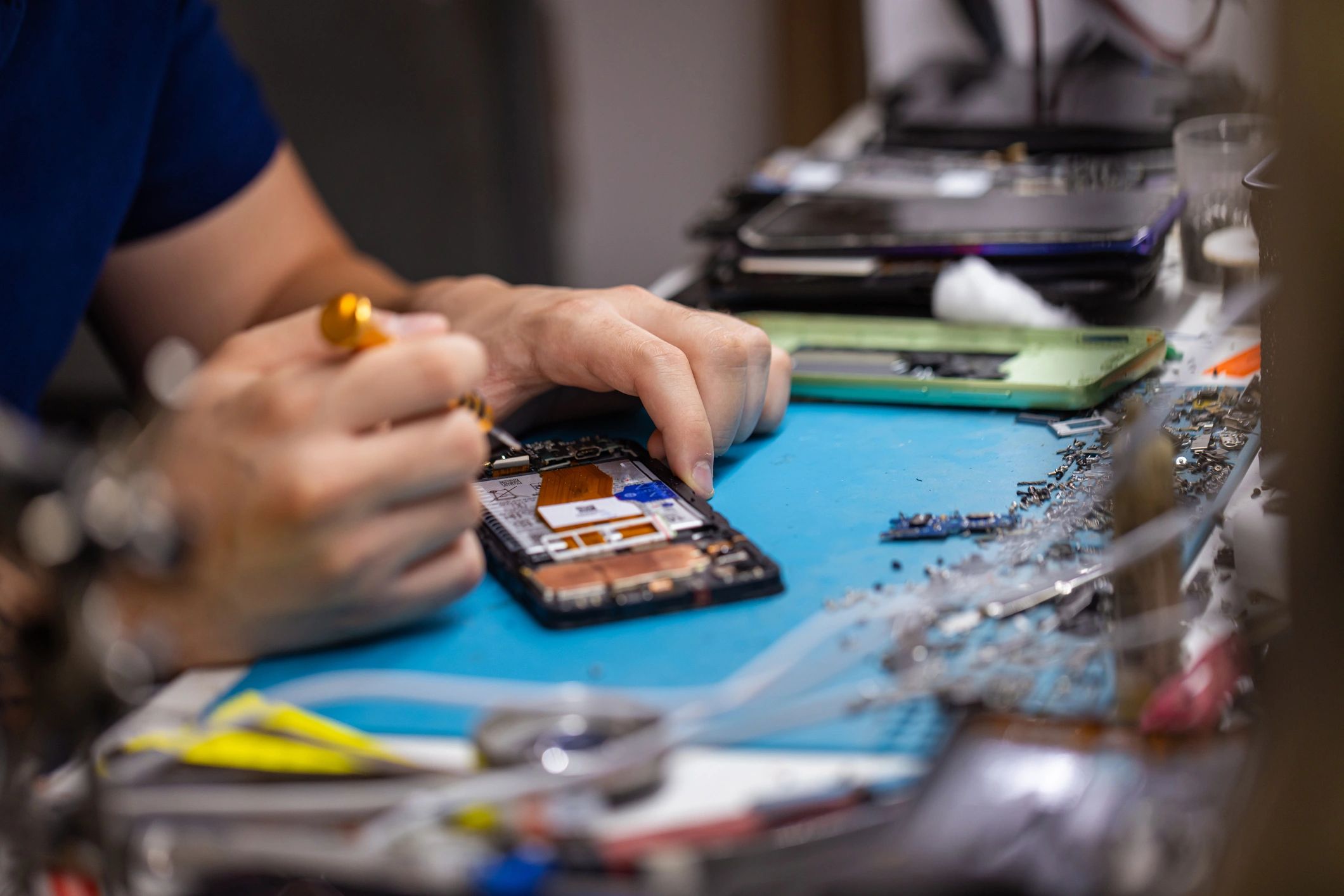Technician repairing a smartphone on a workbench