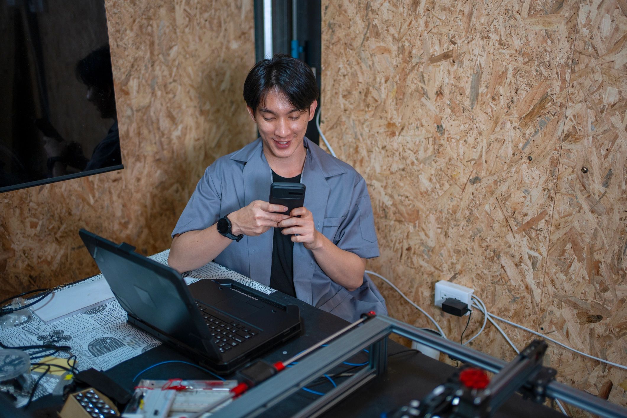 Technician working on smartphone repair at electronics bench